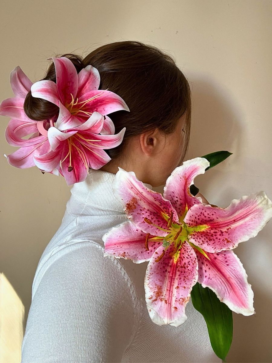woman posing with stargazer lilies and has used these fragrant flowers tied to her hair