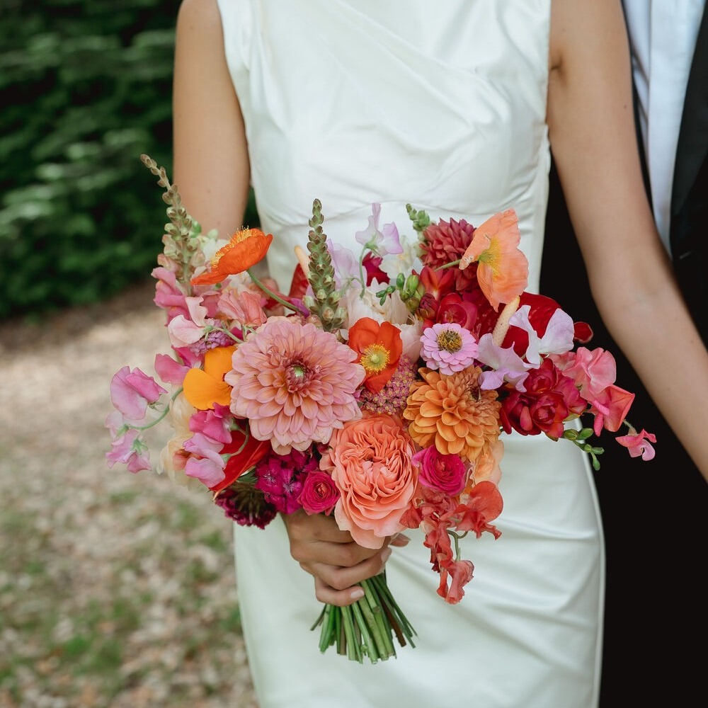 Bride holding colorful summer wedding bouquet