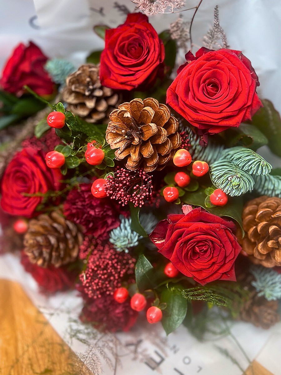 Red roses and other flowers in a festive season bouquet