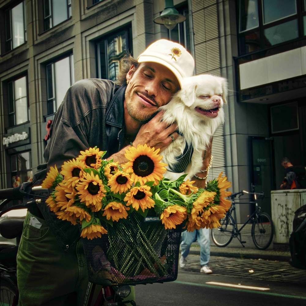 Rapper Greeen biking with sunflowers and dog