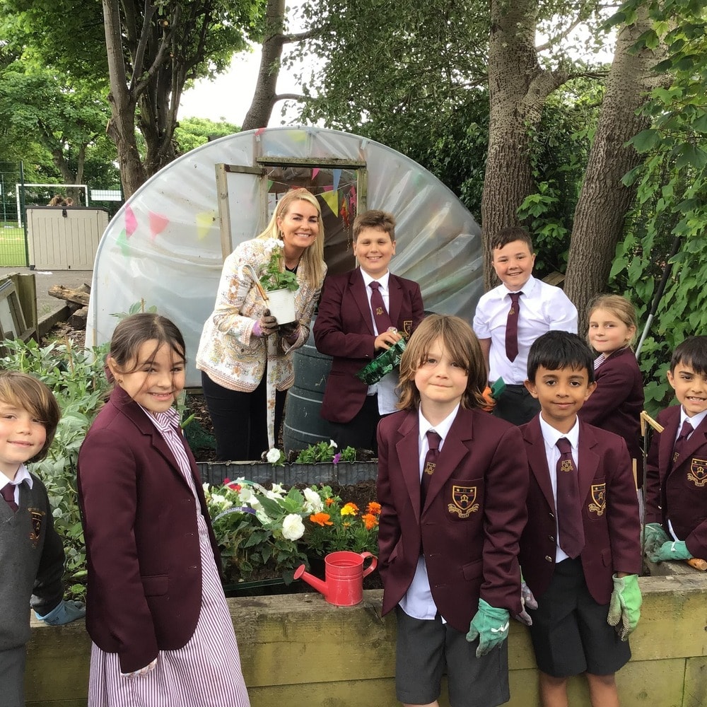 Teacher and students gardening at school