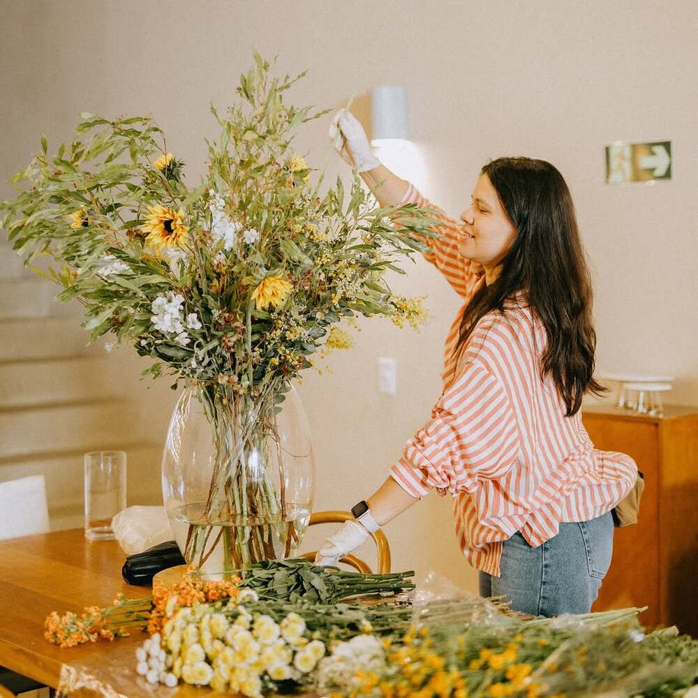 Woman creating large floral arrangement