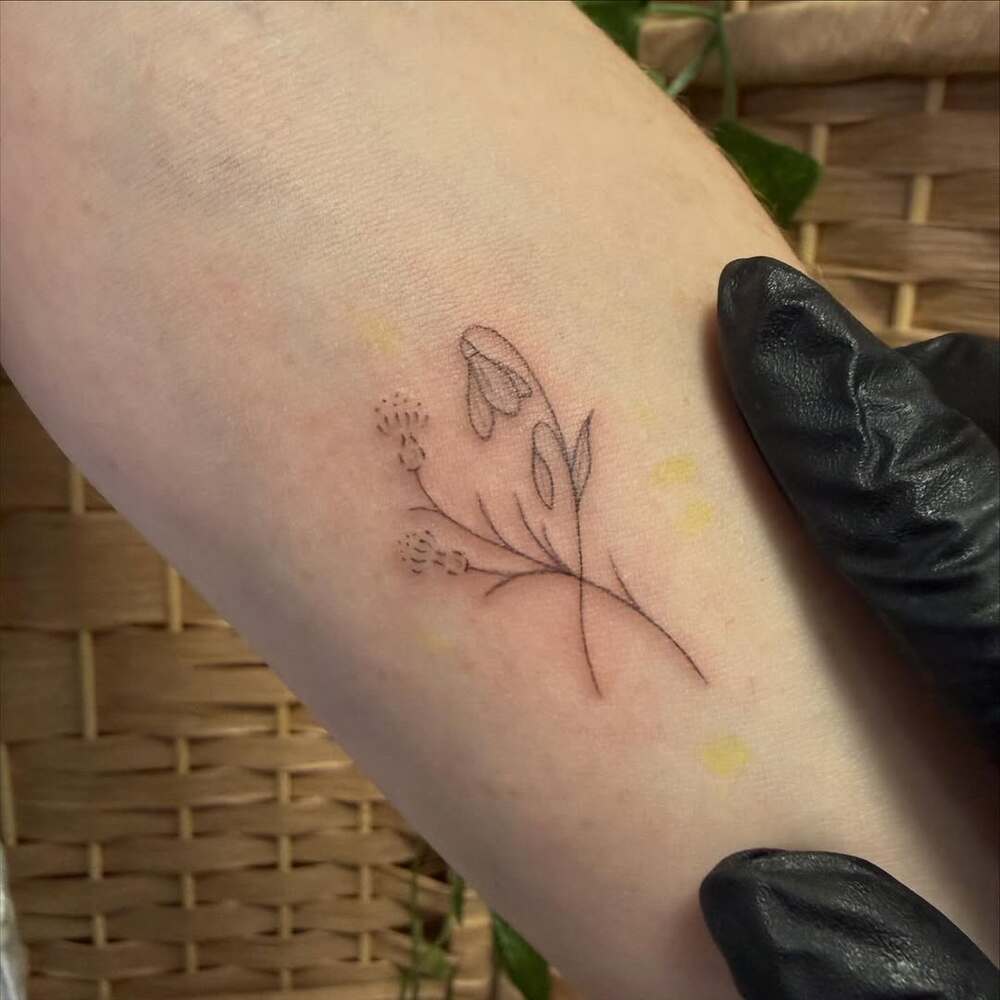 Minimalist snowdrop and thistle tattoo