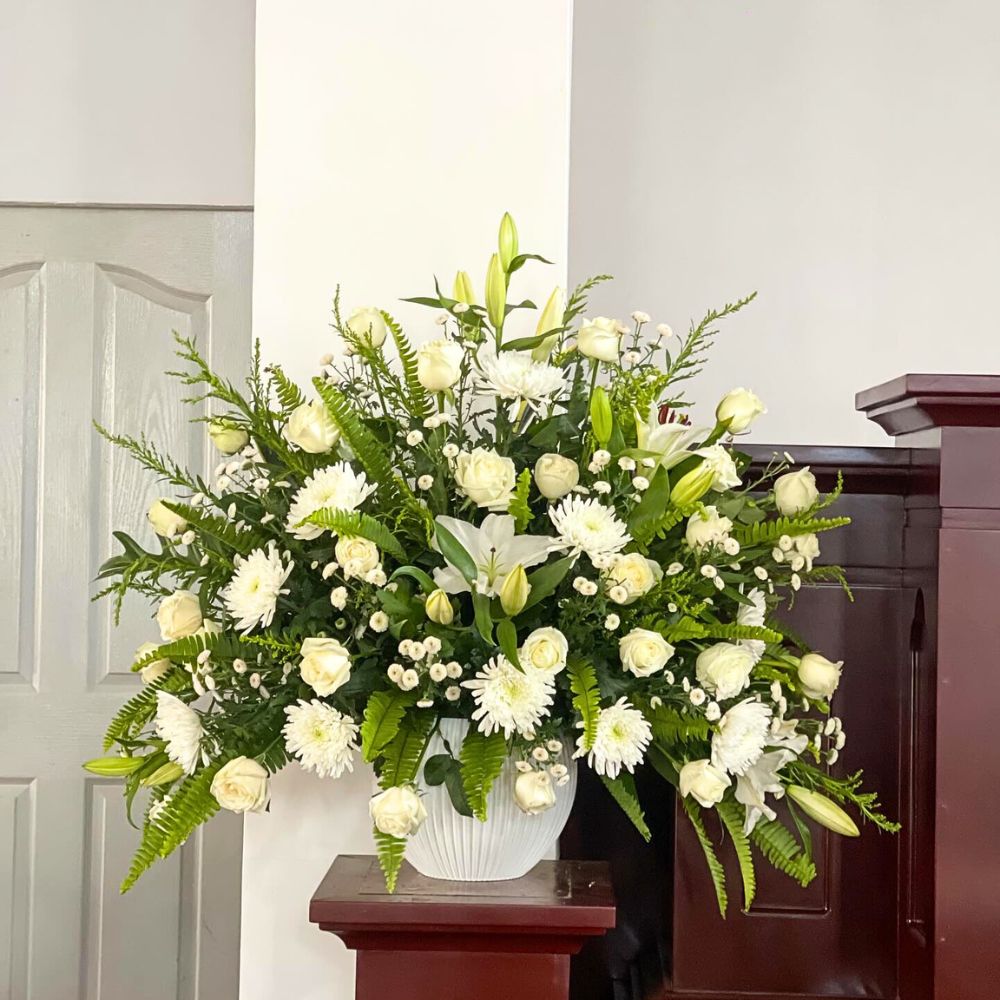 A vase with mixed white flowers at a church altar