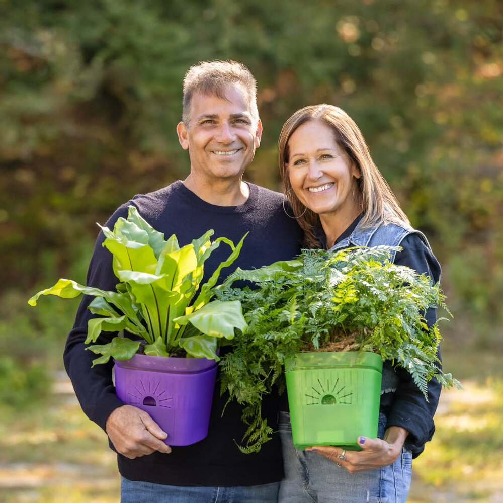 Couple holding vibrant potted plants
