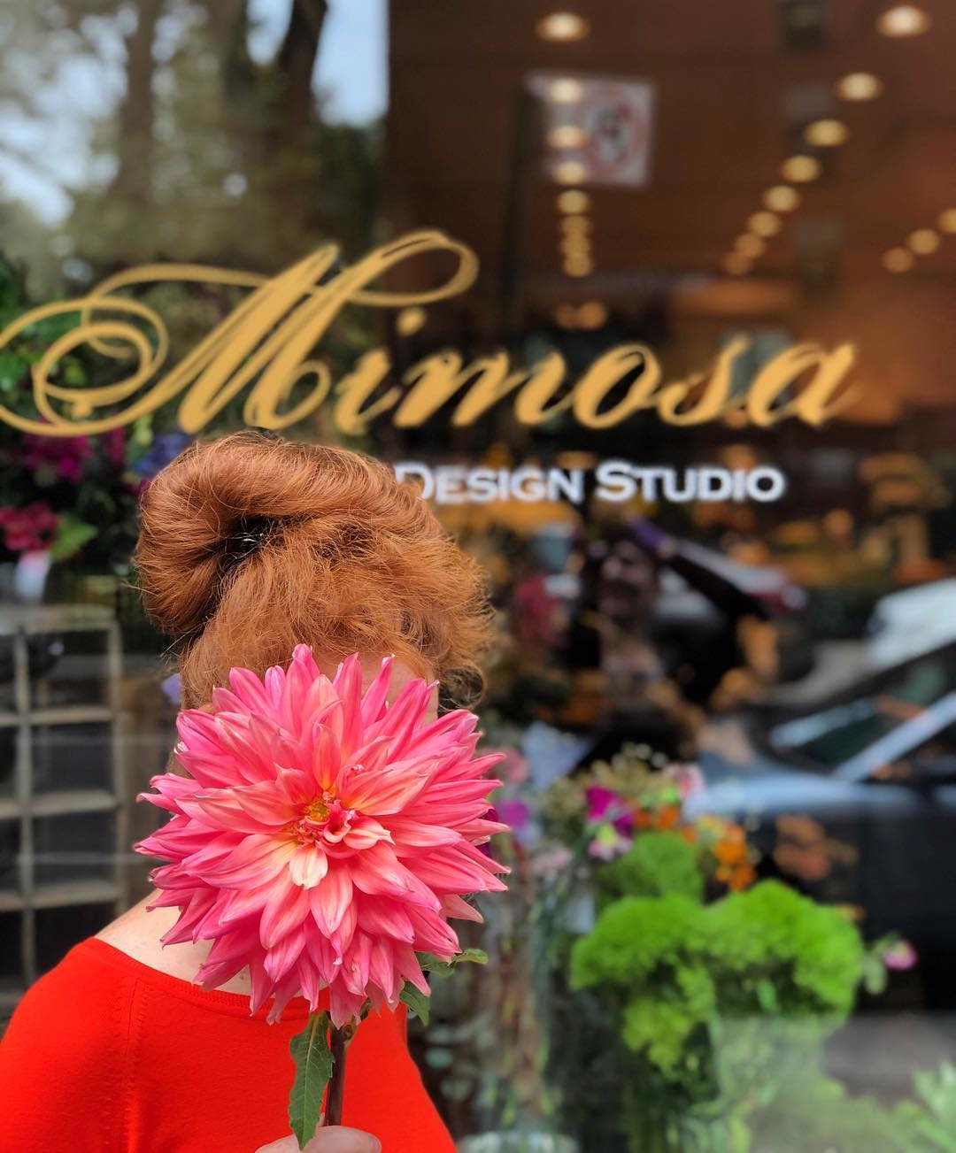 Hiding behind Dahlia - a person standing outside Mimosa Floral Design Studio NYC