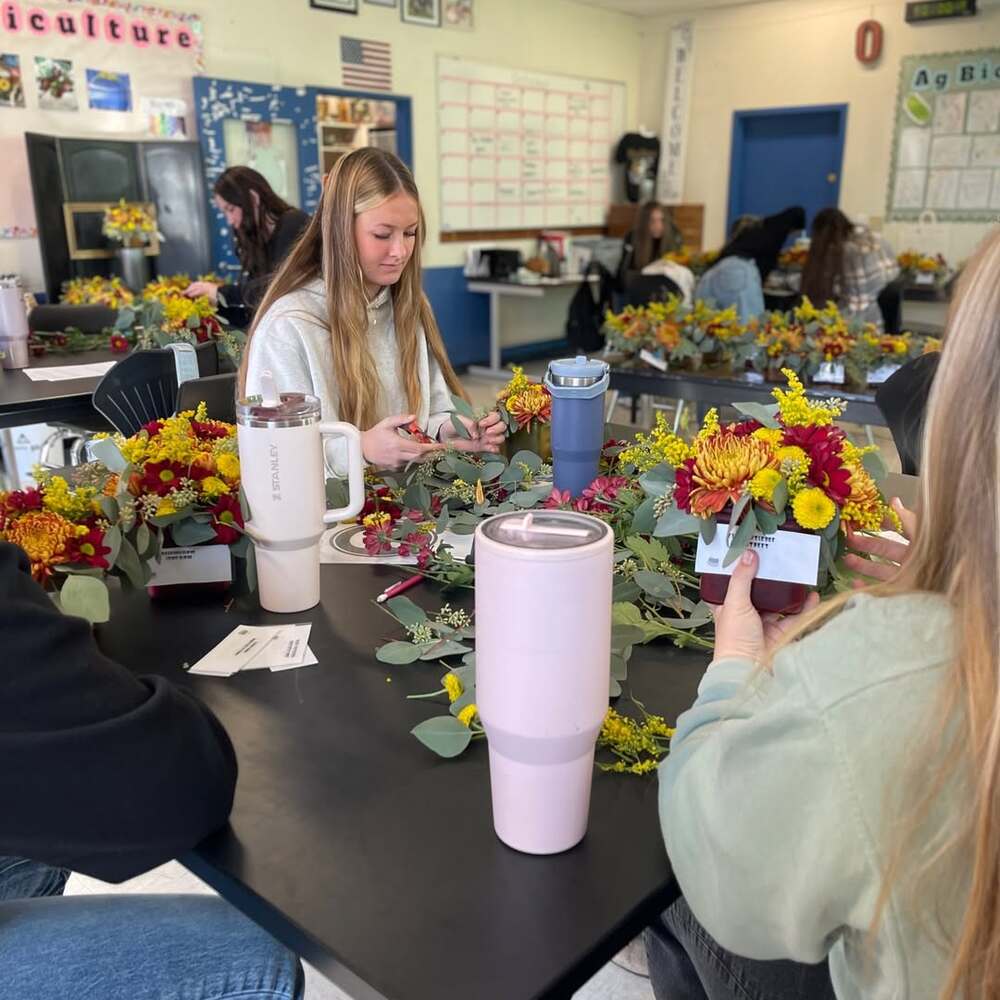 Students creating floral arrangements indoors