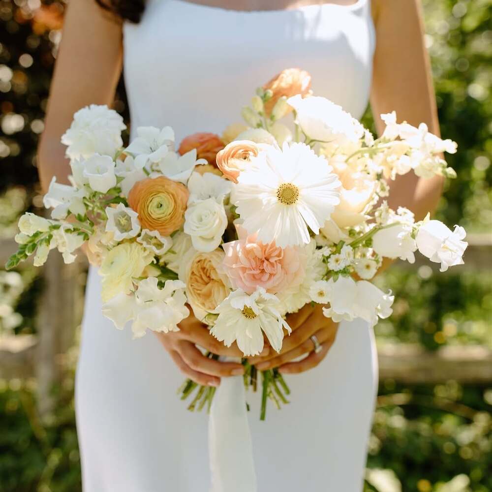 Bride holding sunset-toned garden bouquet