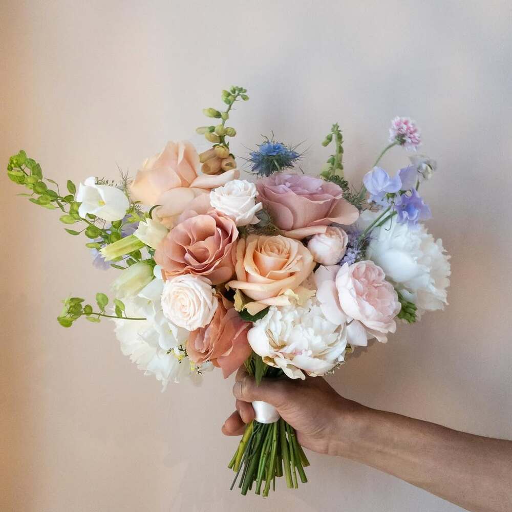 Hand holding a colorful wedding bouquet