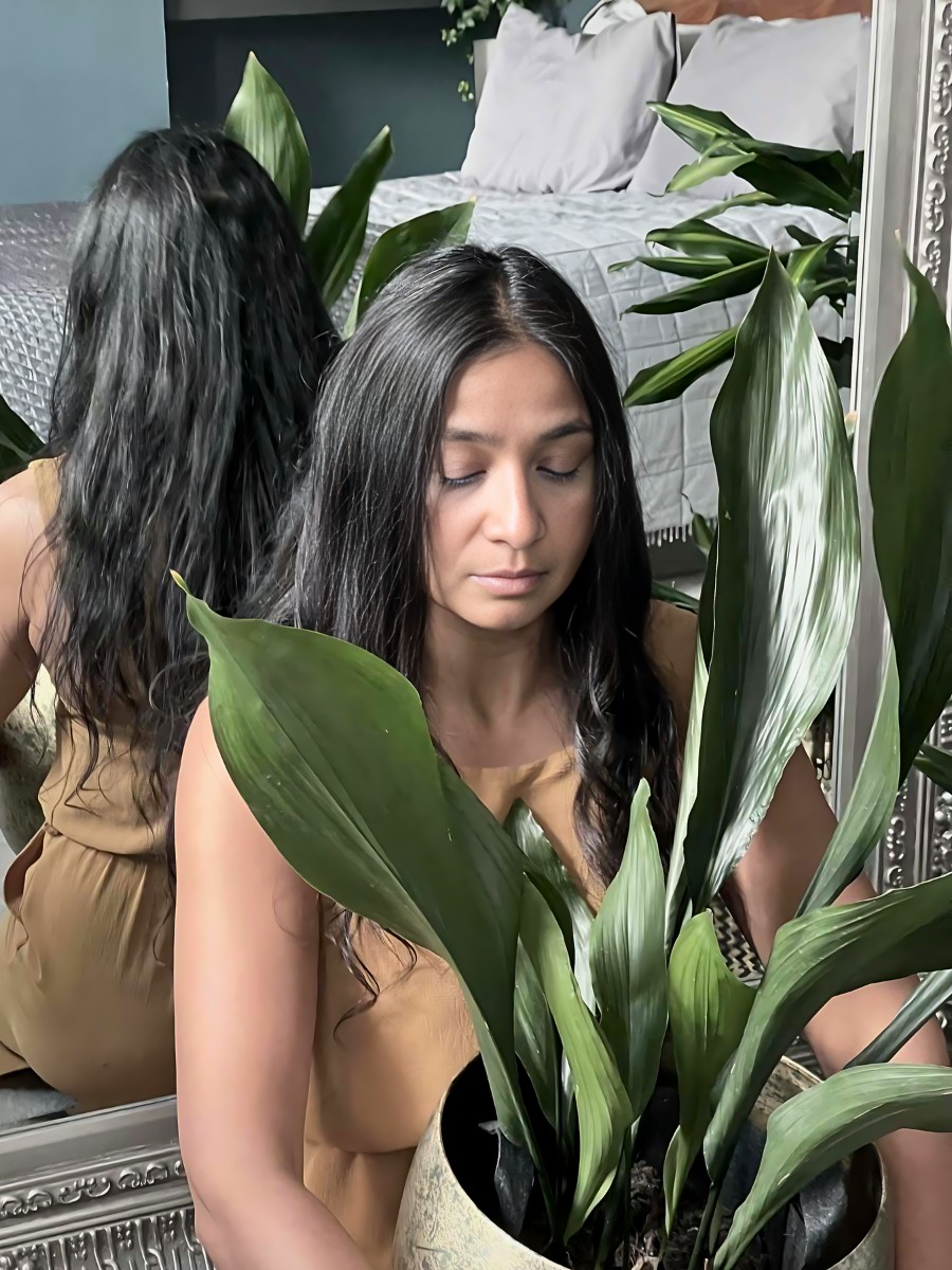 a woman holding a pot of cast iron plant