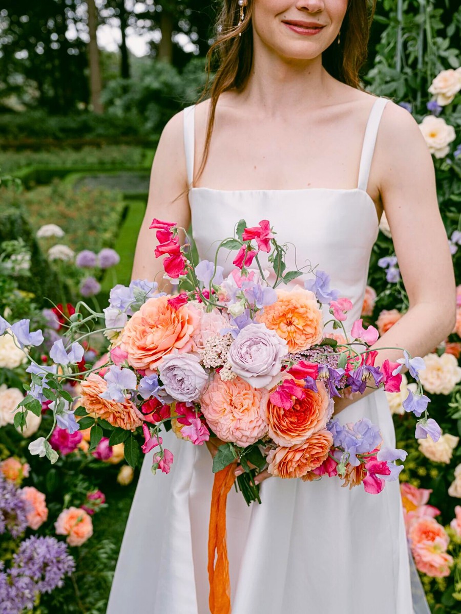 artistic scented arrangement of flowers for a bridal bouquet including trailing vines of sweet peas, clematis, and Dutch garden roses alongside other flowers - Design by Katya Hutter