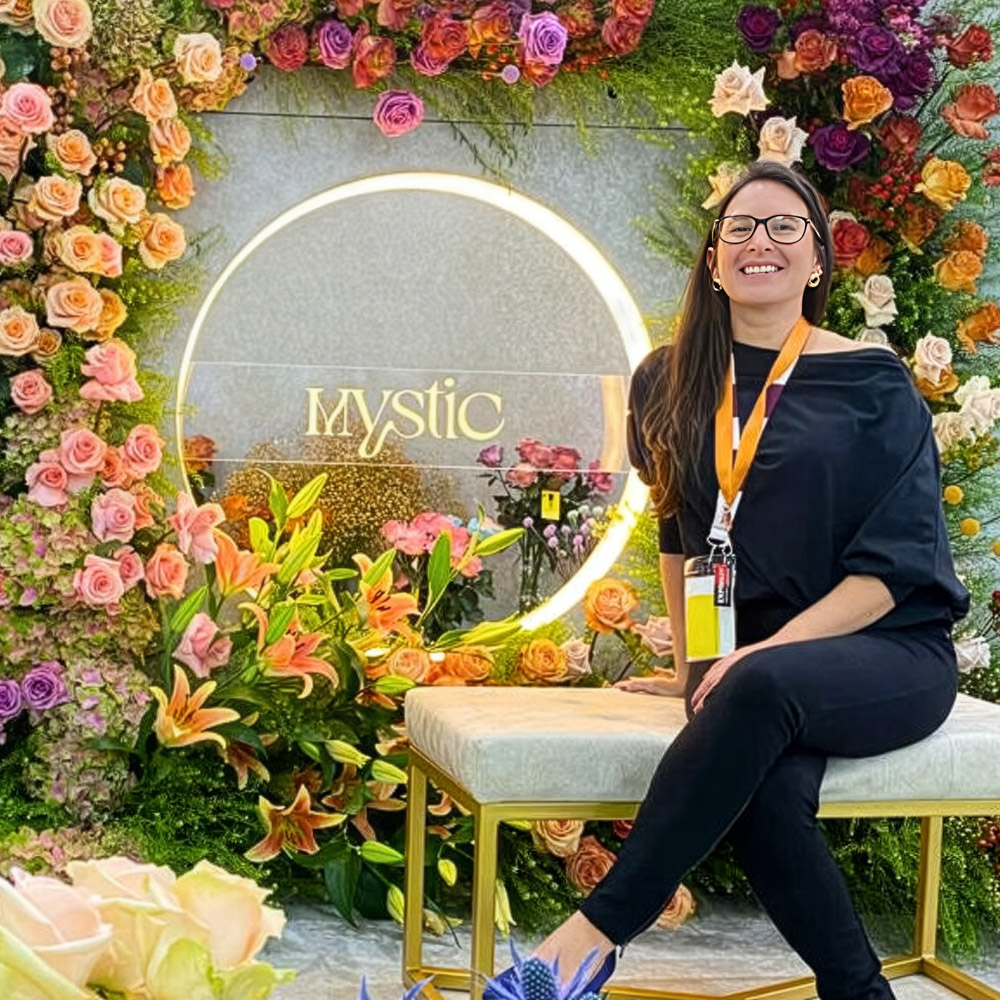 Belen Munoz sitting in Mystic Flowers booth
