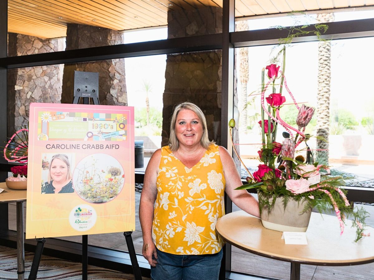 Caroline Crabb posing for a picture with her design submission for the design of the decade competition at AIFD, picture by AIFD Official Instagram page