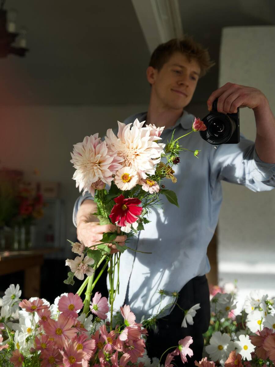 Florist shoot with camera with flowers in shop