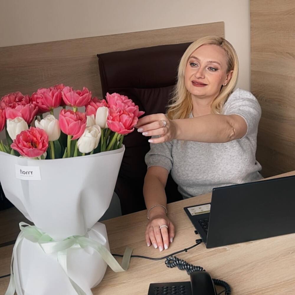 Women florist working on laptop with flower bouquet