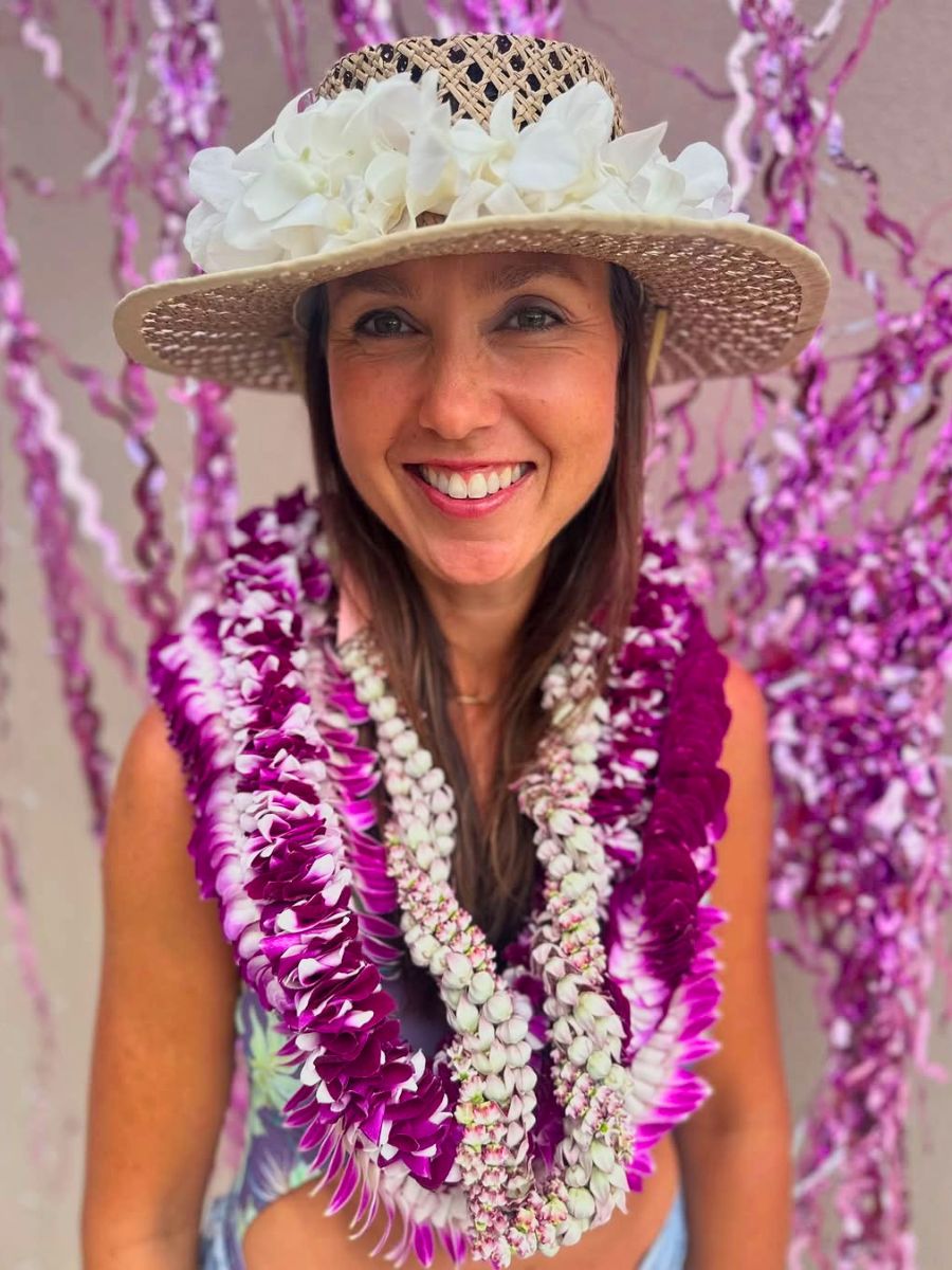 A girl with hot pink flowers on lei