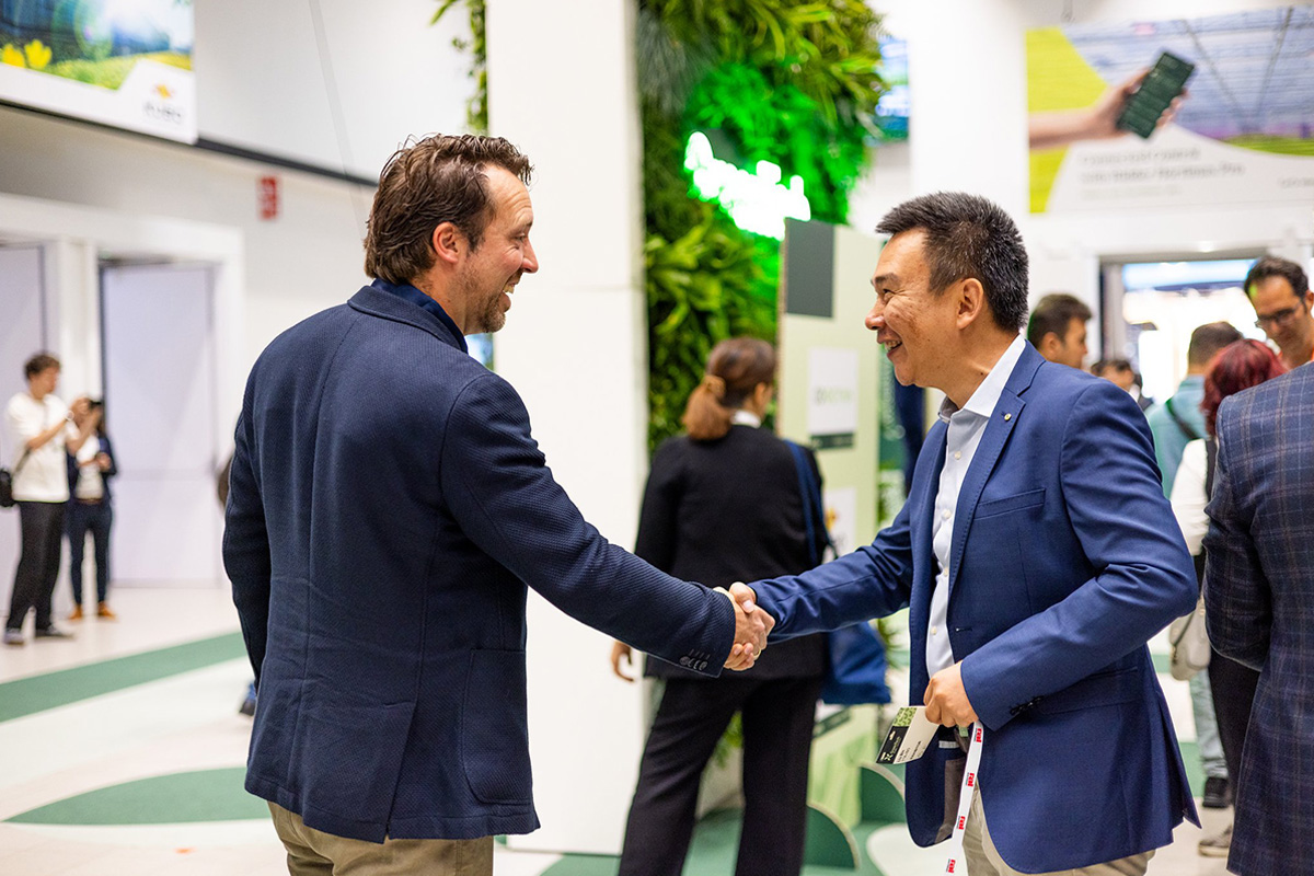 GreenTech Amsterdam 2025 Two laughing men shaking hands