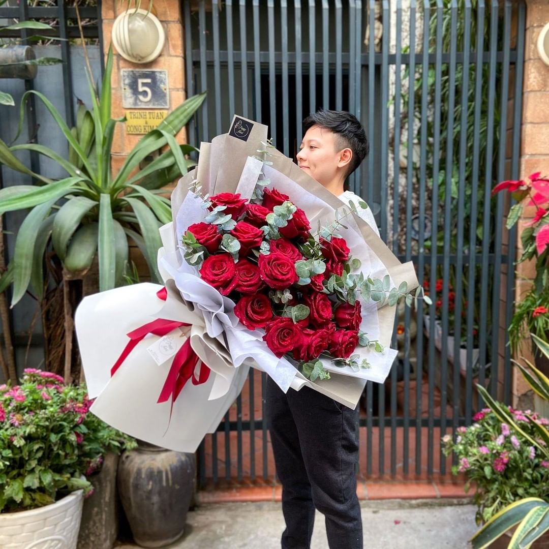 Man holding bouquet of red roses from Ecuador