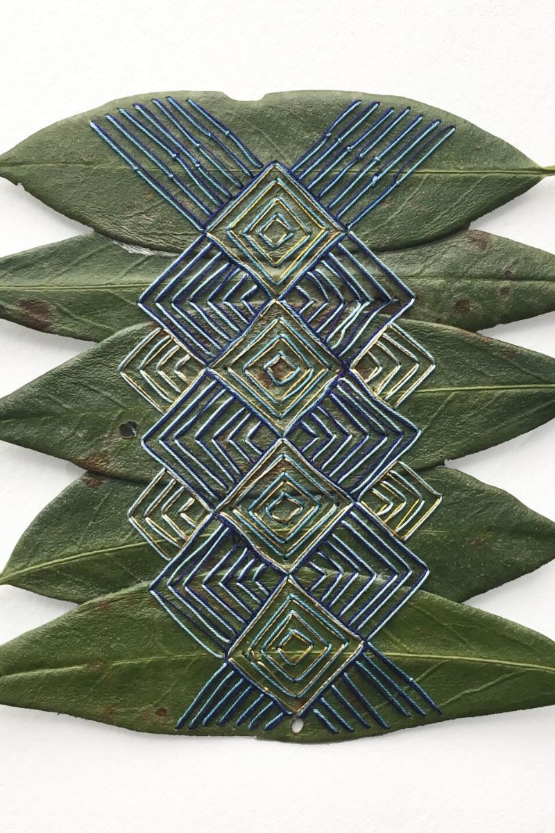 Hillary Waters Fayle blue embroideries in a group of dried leaves on Thursd