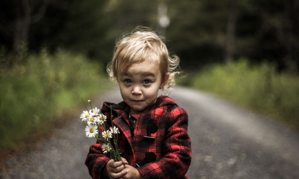 School aged kid giving flowers