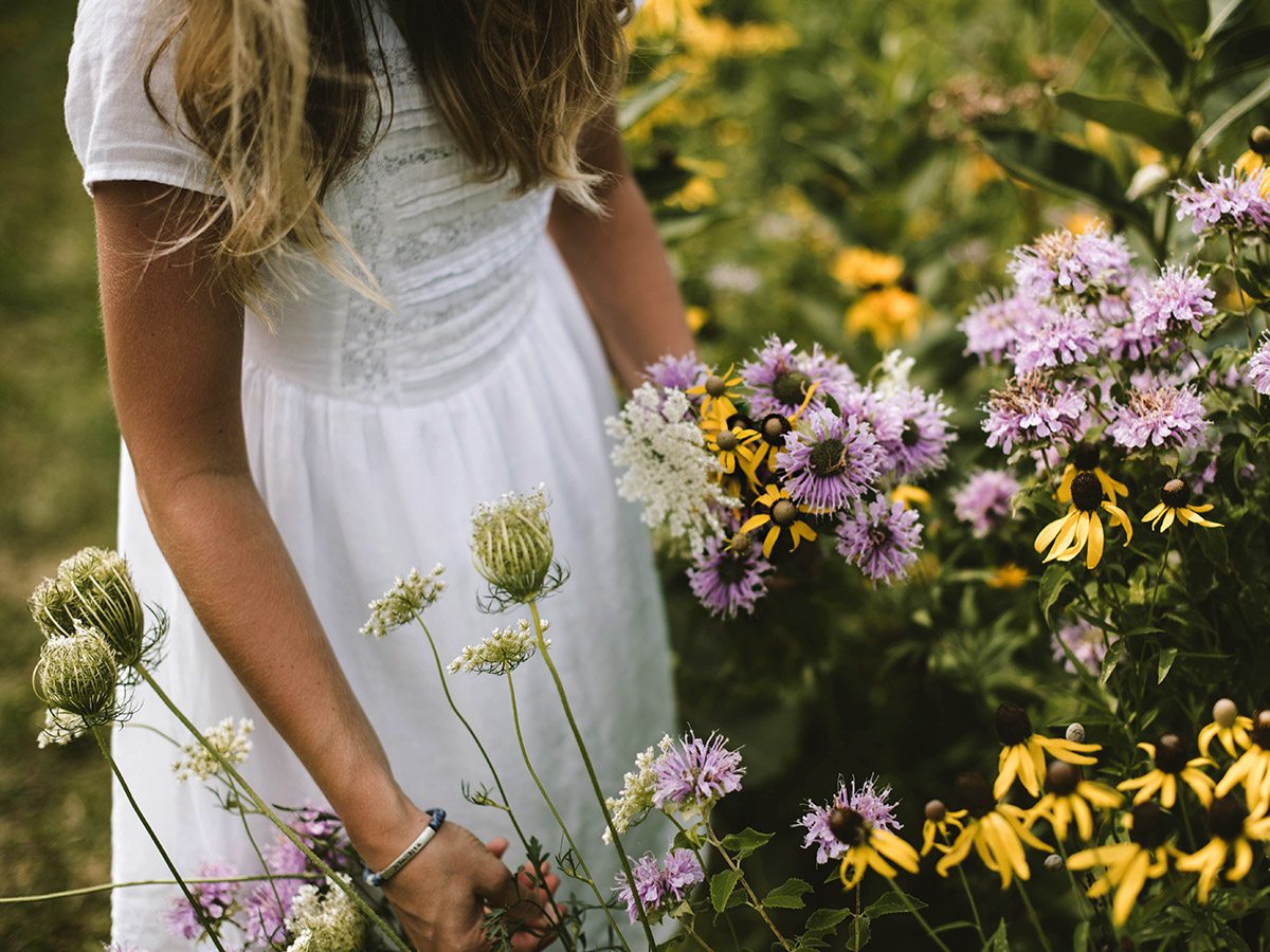 Woman touching flowers by Samantha Gades