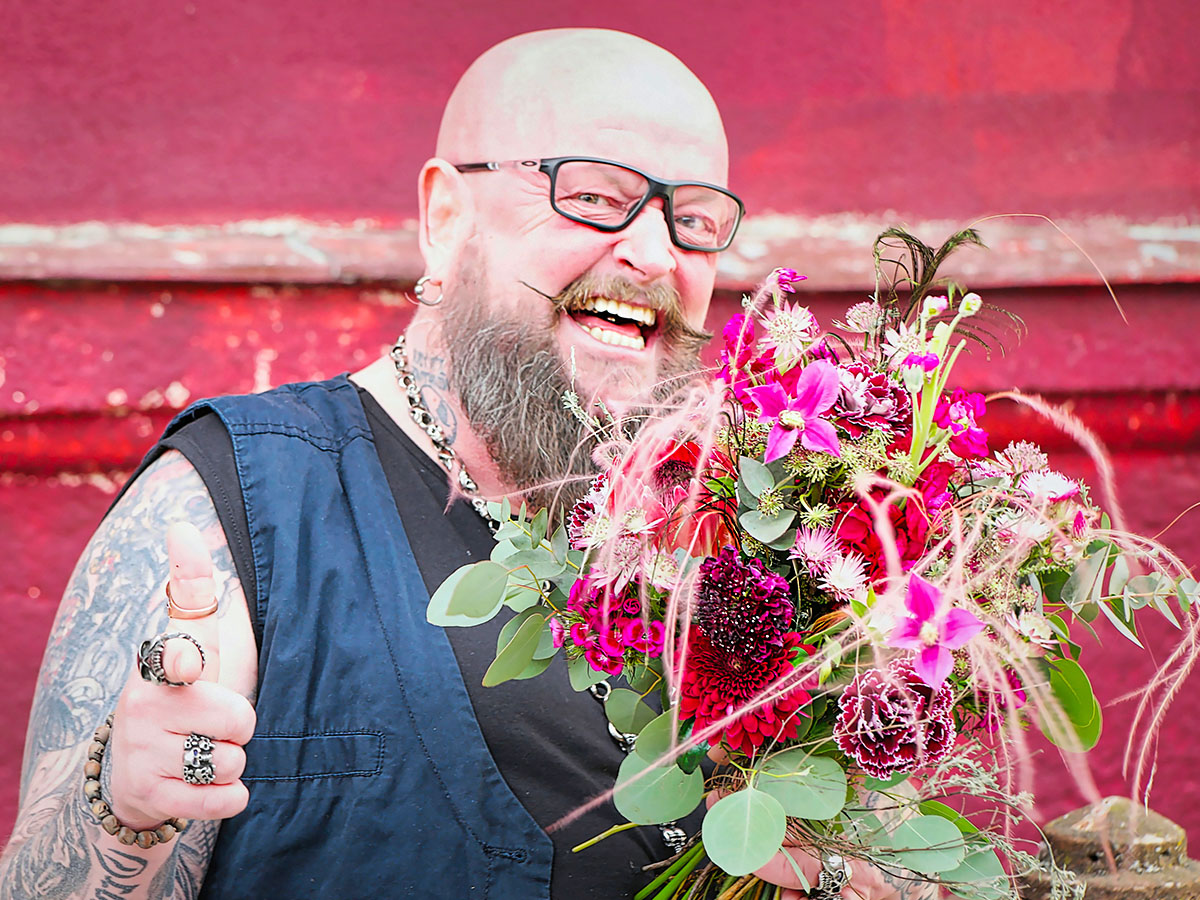 Man with tattoos beard and bouquet