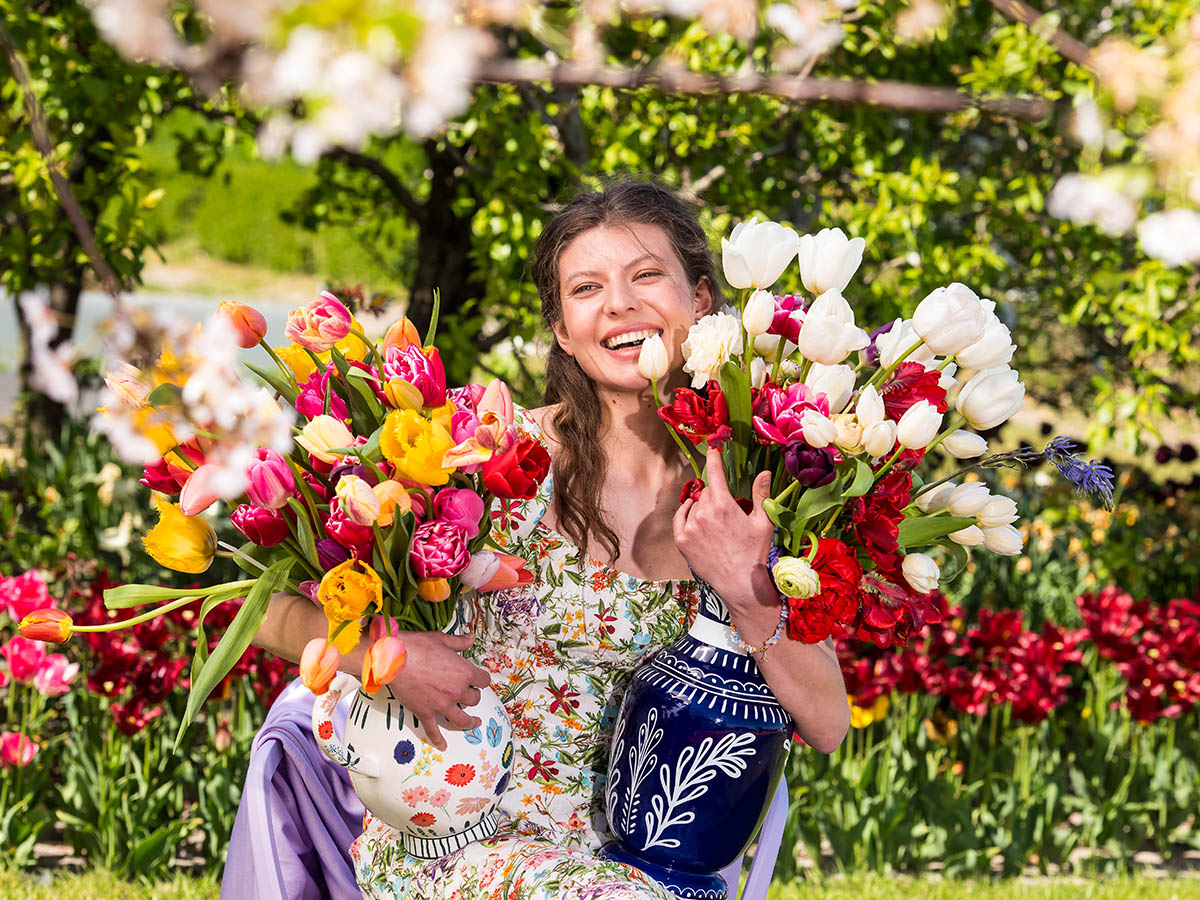 Girl with colored tulips in vases