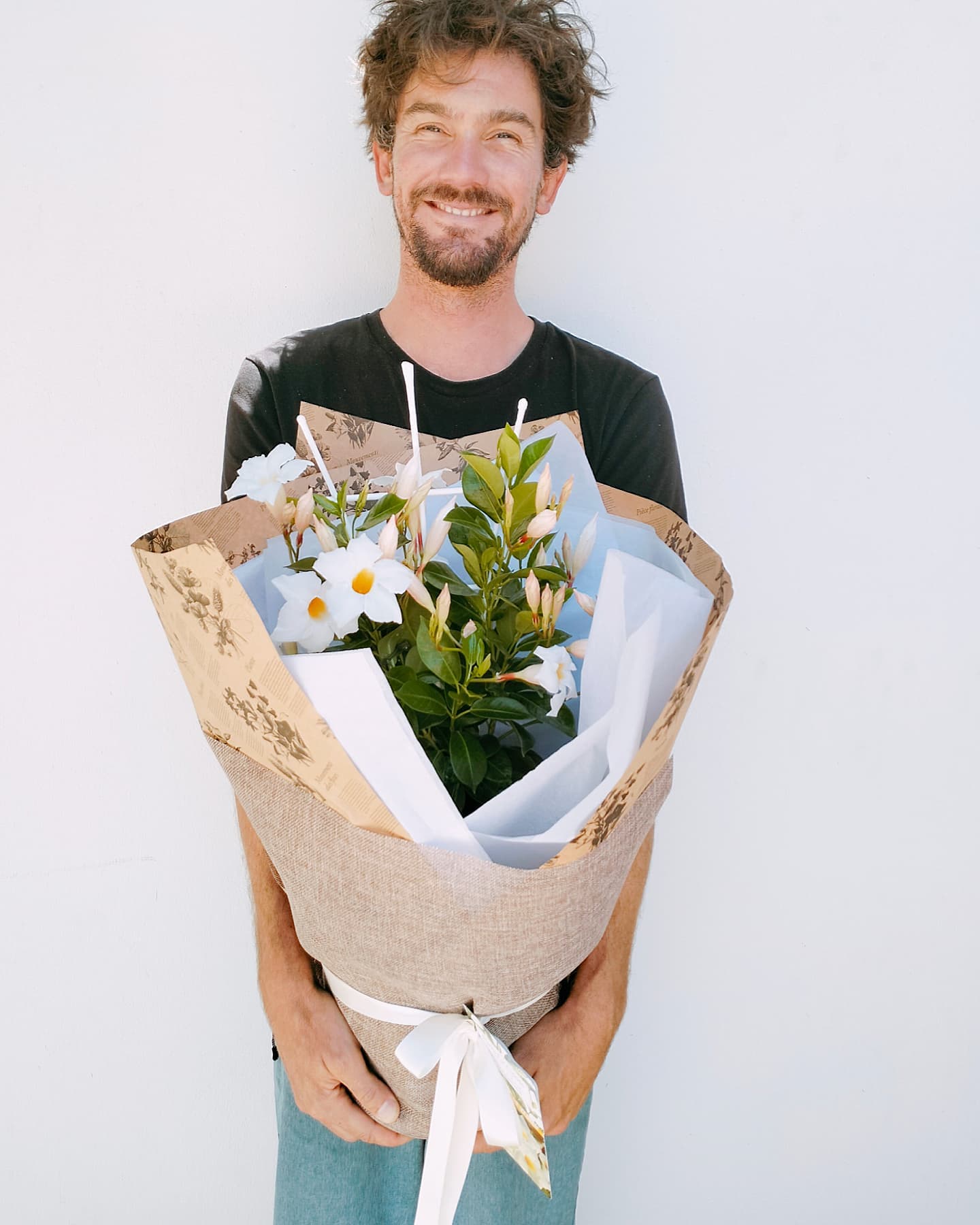 Man Holding White Mandevilla for Mothers day