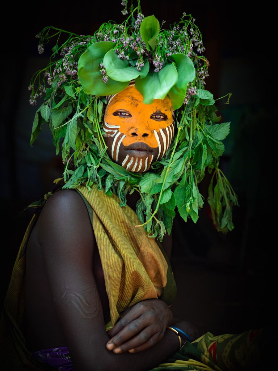 Paintings on faces along with flowers and leaves on Mursi women