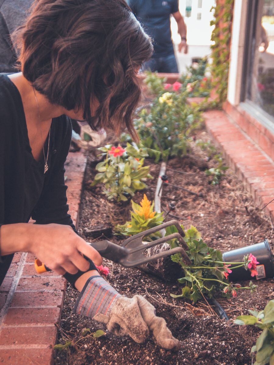 Woman weeding and fixing her garden