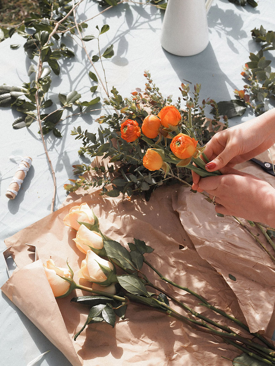 Florist with orange Ranunculus and cream roses