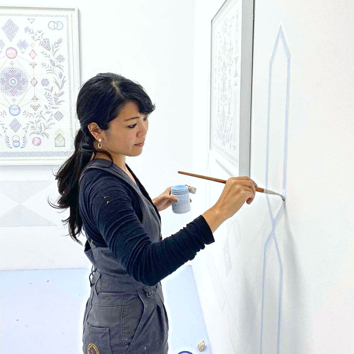 Yuria Okamura painting a mural of plant art