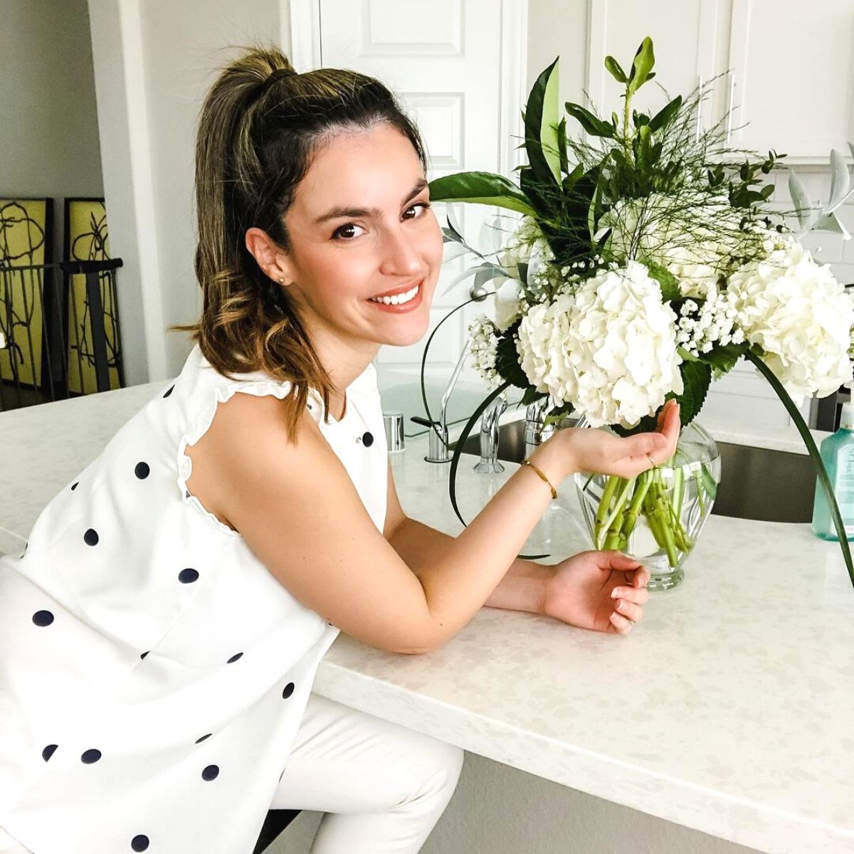 Happy girl with white hydrangeas at home