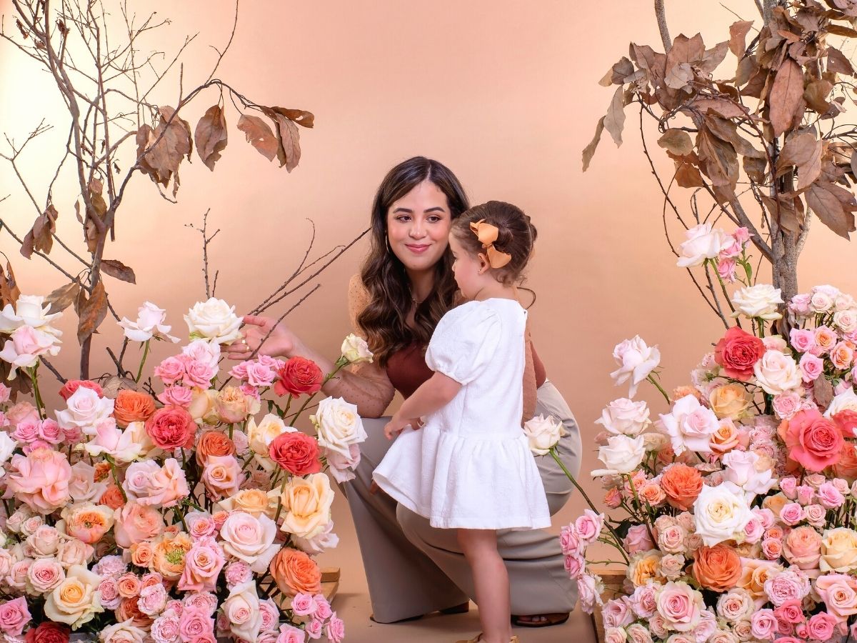 Happy woman and girl surrounded by roses