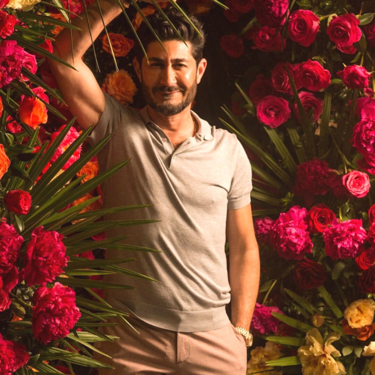 Eddie Zaratsian in between red flowers