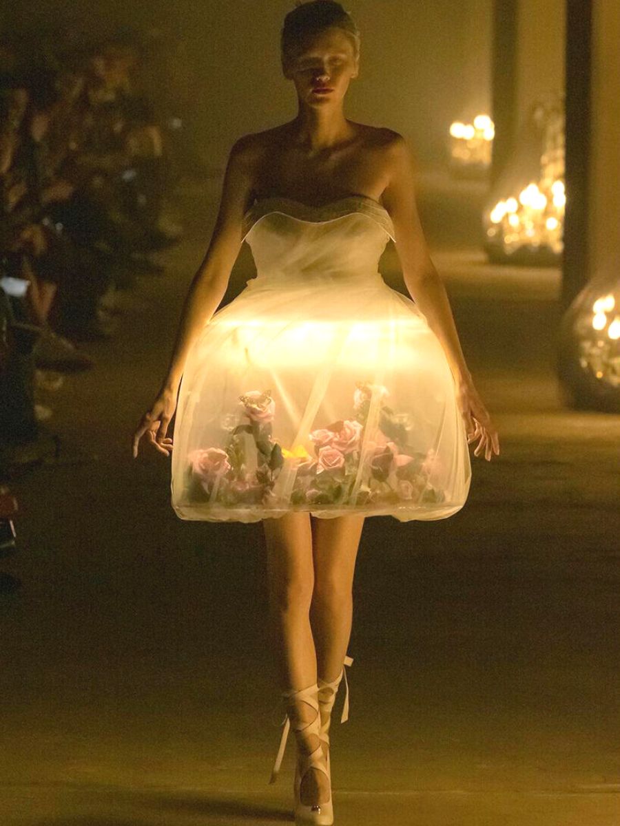 Model walking down the runway with roses in dress