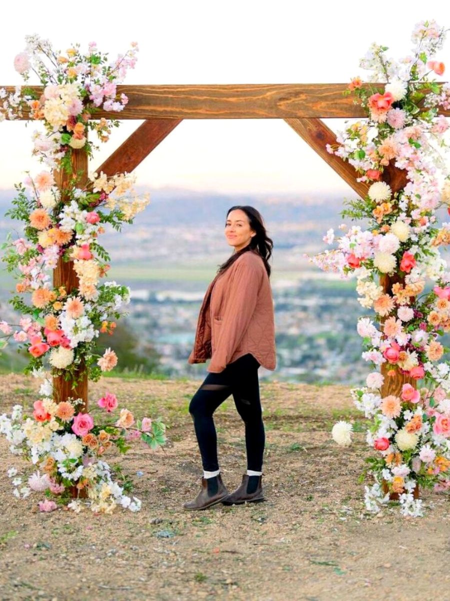 Lily Roden with a flower arch by her