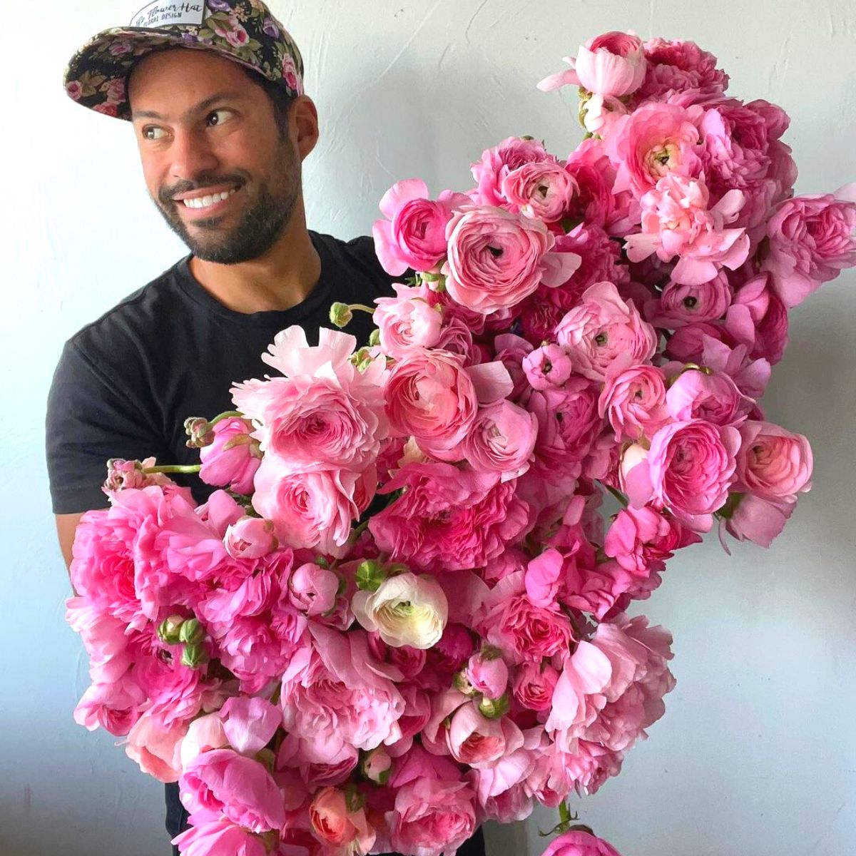 Julio Freitas with an armful of pink flowers
