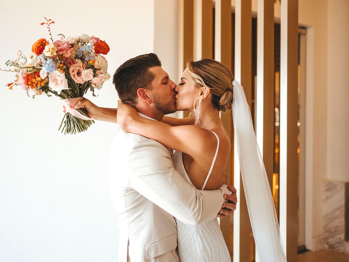 Happy couple with bouquet by Yamile Bulos