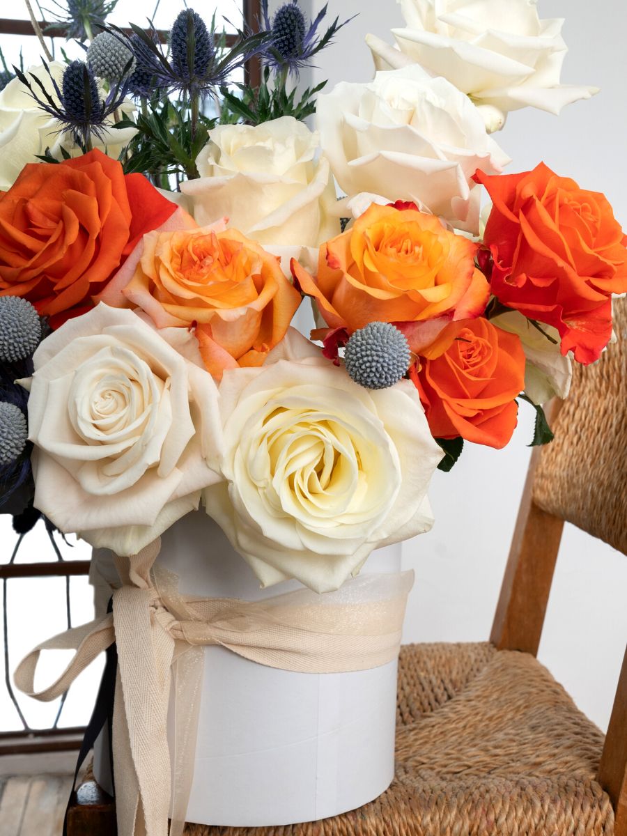 Eryngium with white and orange toned roses