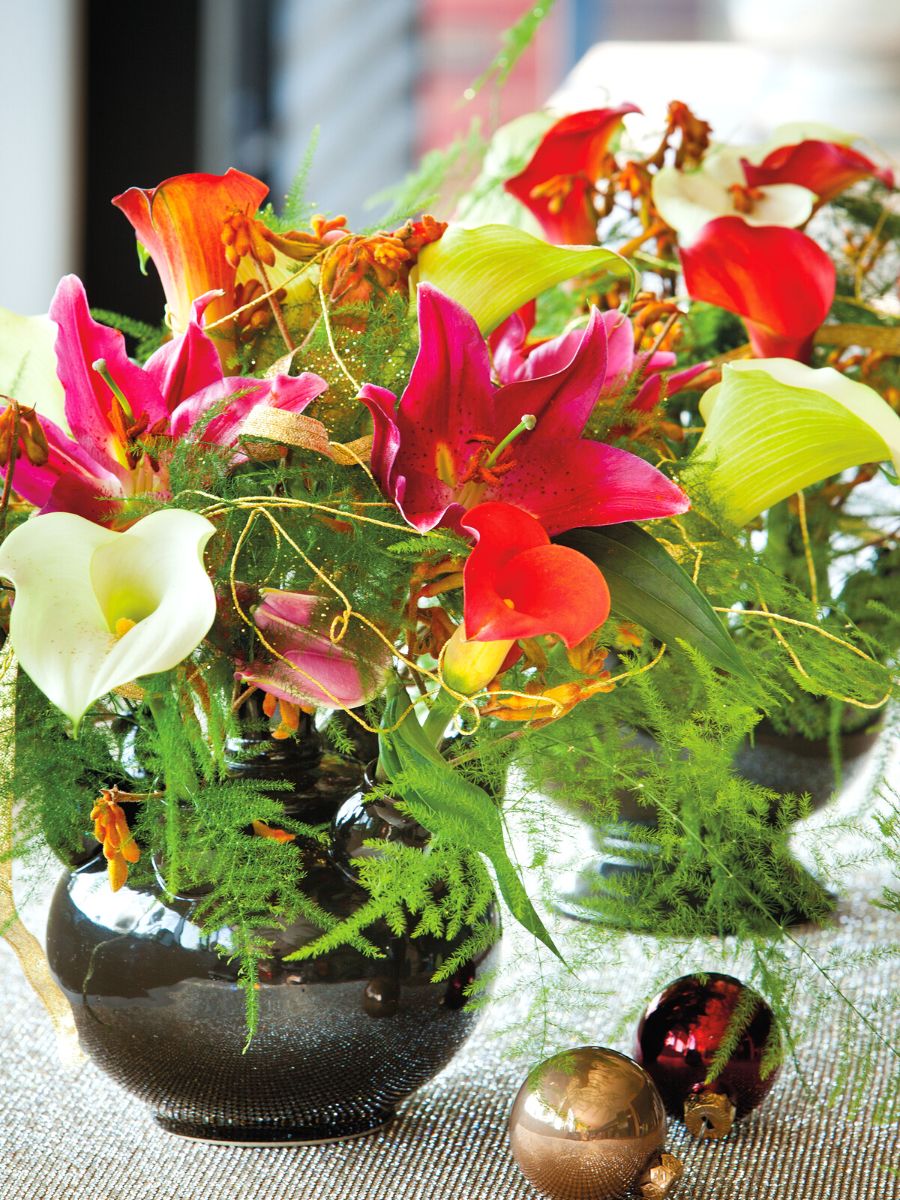 A colorful table center using white and deep orange callas