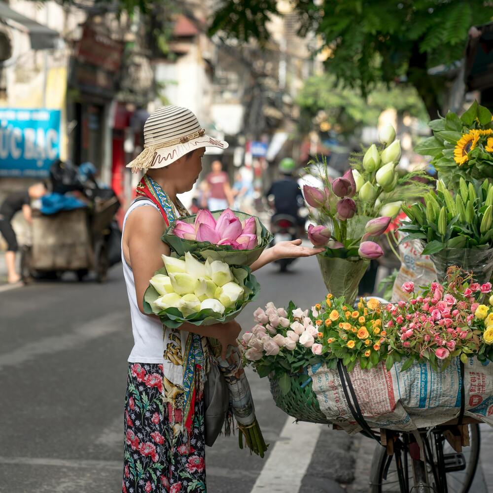 lady buying flower from roadside shop