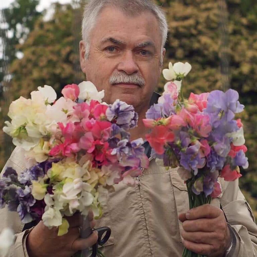 man holding bunch of sweet peas flowers