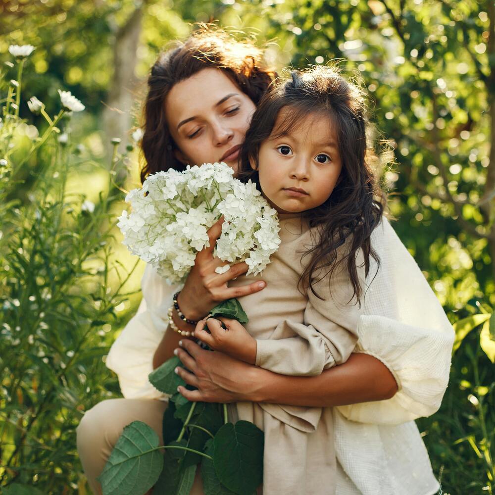 Mother holding child with flowers