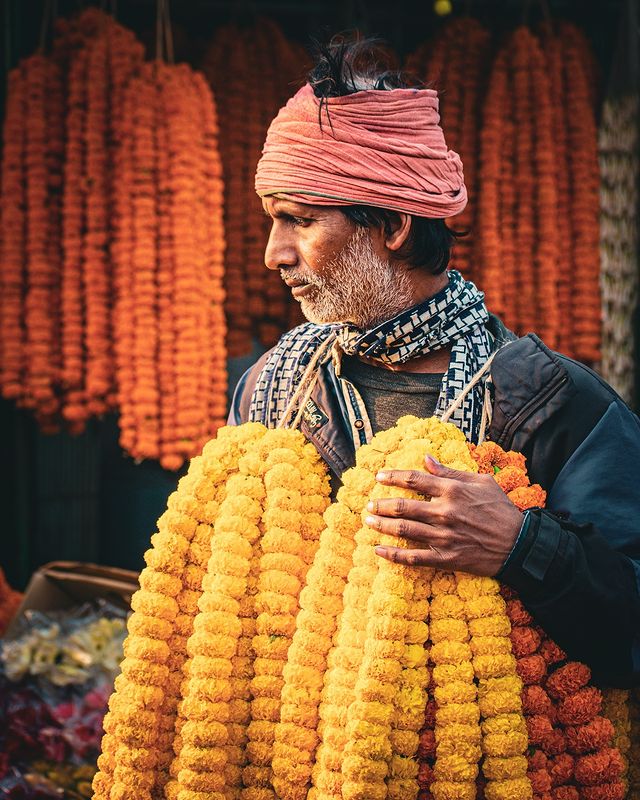 man selling garlands in indian wholesale flower market