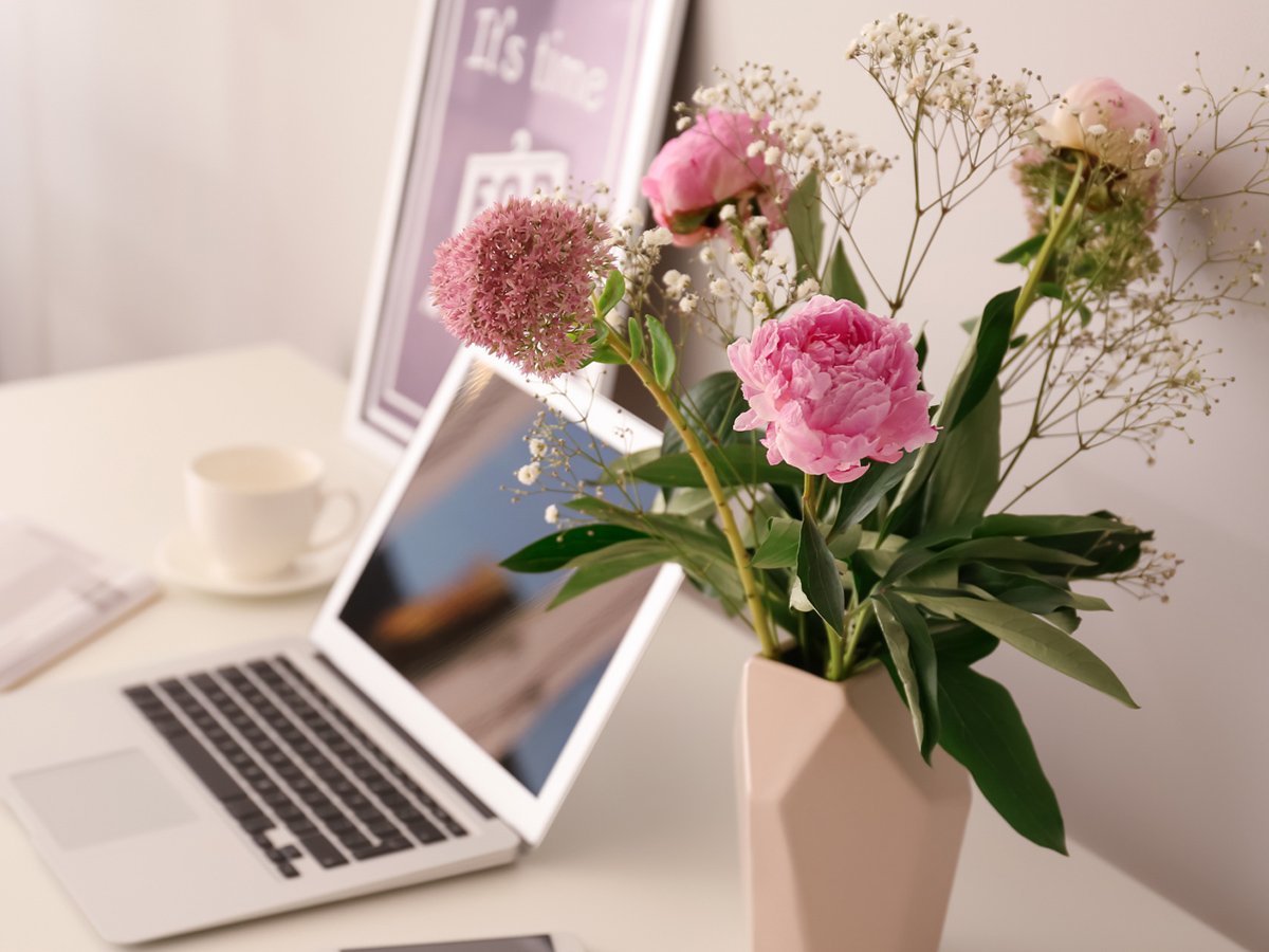 Pink peony in a vase with a laptop