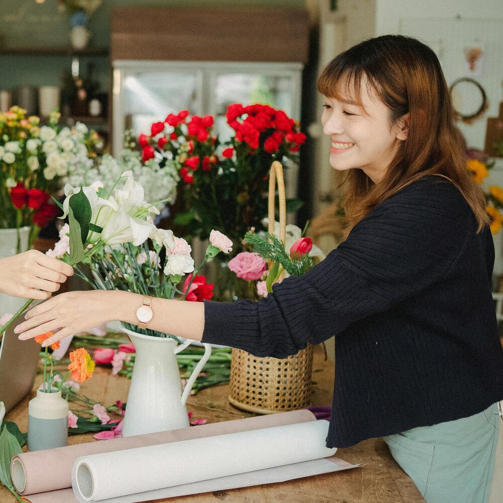 Lady arranging flower bouquet in shop