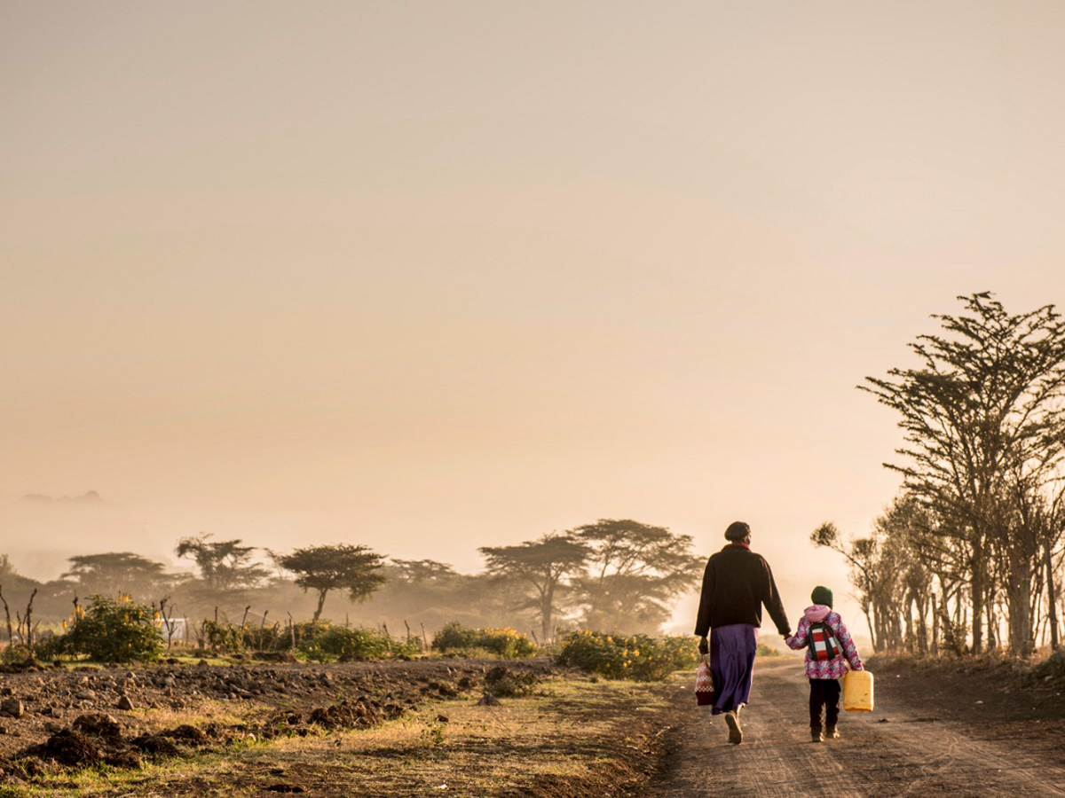 Tambuzi farm worker with her kid walking