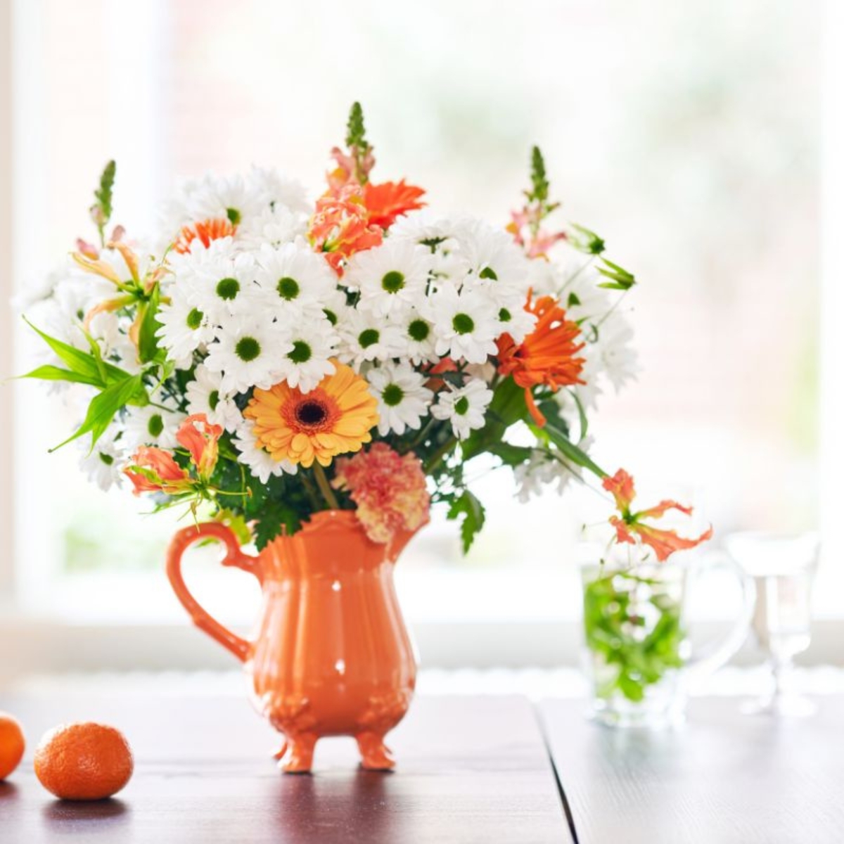 White mums in an orange vase