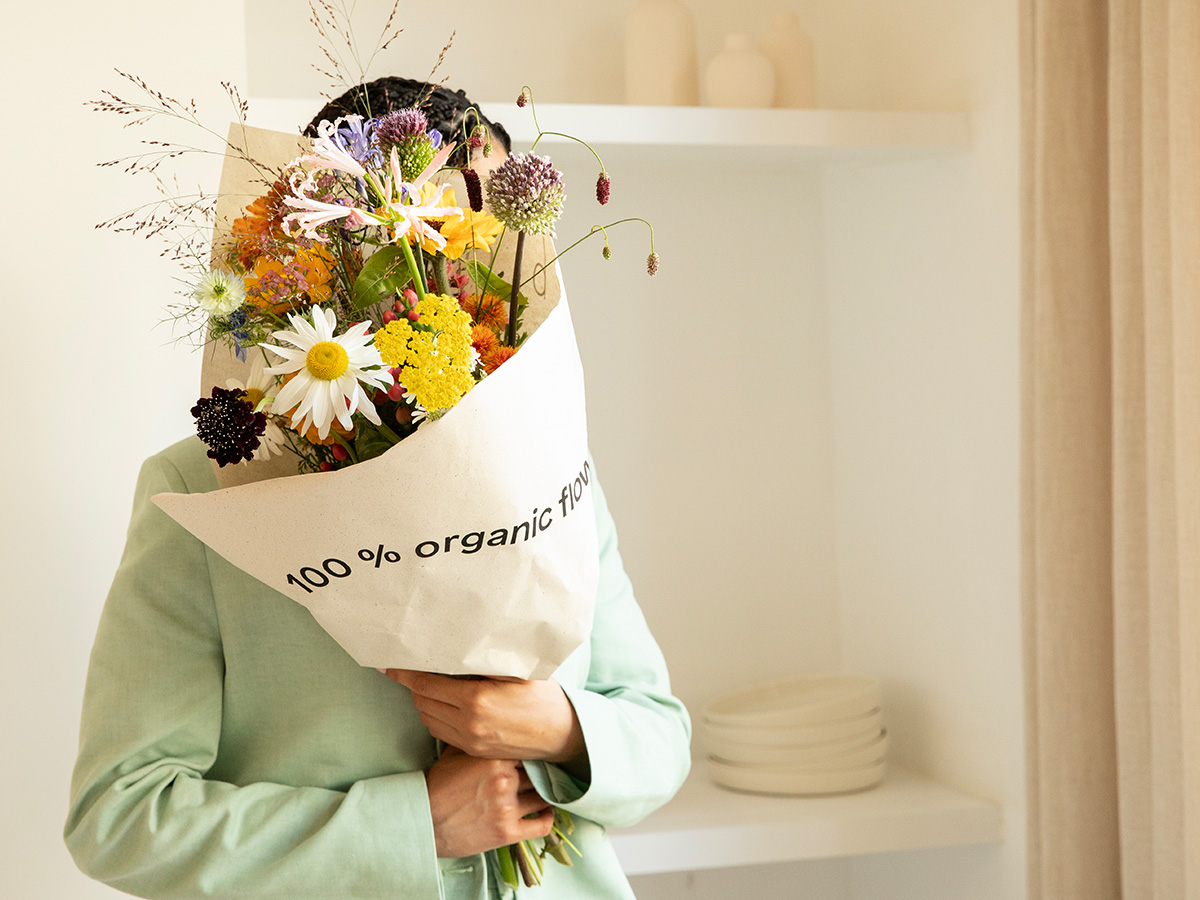 Bloomon Model with wrapped 100 percent organic bouquet